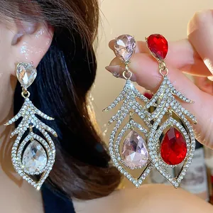 Detail shot of vintage hollow feather earrings with teardrop crystals in three colors.