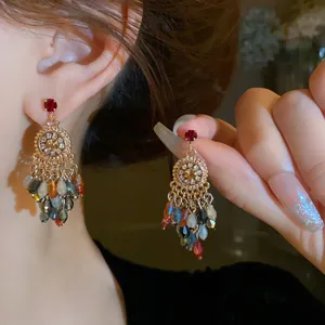 Close-up of elegant crystal tassel earrings with colorful beads and rhinestone flowers