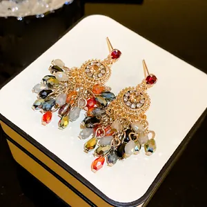 Detailed view of colorful crystal tassel earrings with gold-toned rhinestone studs