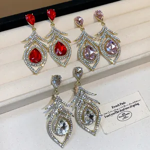 Detailed view of vintage palace style feather earrings in red, pink, and white crystals