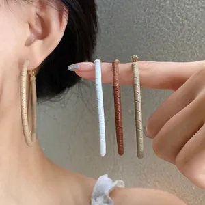 Elegant leather-wrapped hoop earrings in multiple colors worn by model