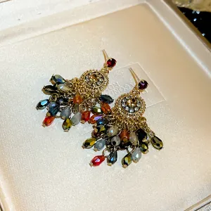 Macro view of elegant crystal tassel earrings featuring sparkling multi-colored beads and gold