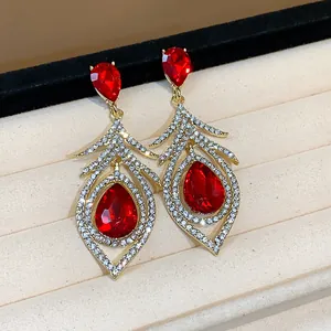 Close-up of retro palace style earrings with red crystals and feather rhinestones