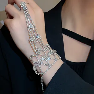 Detailed close-up of a sparkling rhinestone finger bracelet with dangling chains.