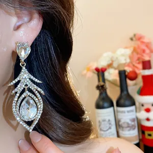 Close-up of luxury vintage hollow feather earrings with brilliant rhinestones on model