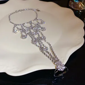 Close-up of elegant rhinestone hand chain bracelet with integrated ring on ceramic plate
