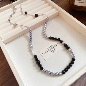 Elegant vintage acrylic pearl necklace with black and grey beads in a jewelry tray