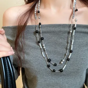 Close-up of a double-layered vintage acrylic pearl necklace with black and grey beads.