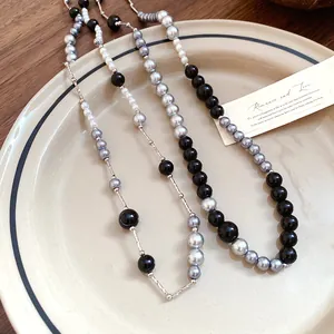 Macro view showing the textures of retro black and grey acrylic pearl necklaces.