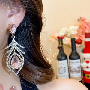 Detailed view of luxury feather-shaped drop earrings with pink gems and rhinestones