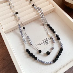 Detailed view of elegant layered retro acrylic pearl necklace in grey and black pearls