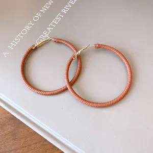 Detailed view of fashionable brown leather-wrapped round hoop earrings for women