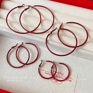 Elegant Ancora red hoop earrings in four different sizes displayed on a jewelry tray
