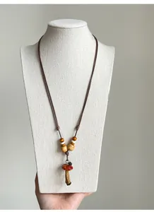 Close-up of a vintage handmade mushroom pendant necklace with wooden beads