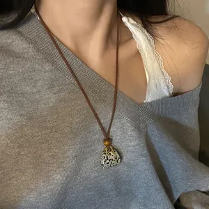 Vintage mini bag pendant necklace with wooden bead and dalmatian stone pattern.