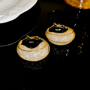 Close-up detail of elegant gold-toned mesh moon boat earrings with sparkling crystal inlay