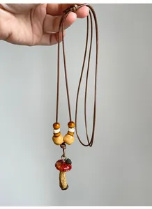 Detailed view of handheld vintage ethnic style mushroom necklace with wooden beads.