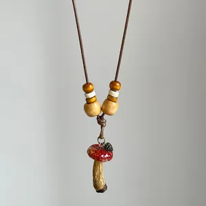 Detailed macro view of vintage mushroom pendant necklace with wooden beads and cord