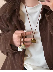 Detail view of miniature handbag pendants in diverse stone textures on leather cords.