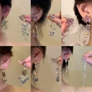 Eleganti orecchini con nappe di cristallo, motivi a farfalla e fiori con perno in argento.