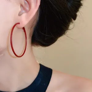 Close-up of stylish Ankara red hoop earrings worn on ear