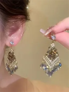 Detail view of elegant silver needle earrings featuring zircon flower and crystal tassels