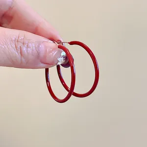 Close-up of minimalist Ankara red round hoop earrings with sterling silver needles