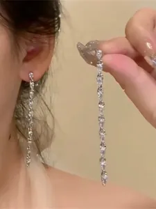 Close-up of elegant silver tassel earrings with sparkling pear-cut zircon crystals
