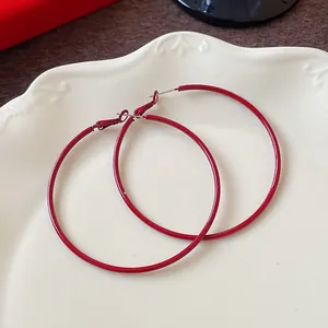 Elegant large Ankora red hoop earrings with minimalist circular design and silver needles.