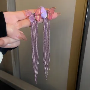 Primo piano di eleganti orecchini a farfalla con lunghe nappe di perline