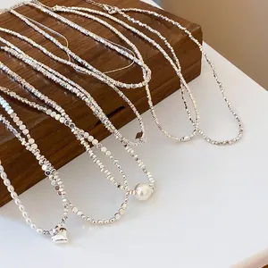 Elegant silver-colored minimalist geometric necklaces featuring heart and pearl pendants