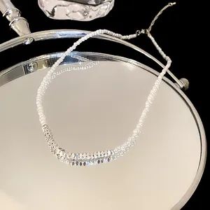 Elegant silver geometric bead necklace with white pearls displayed on mirror reflection
