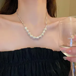 Detail showing textured silver bead necklace on model neck for elegant style