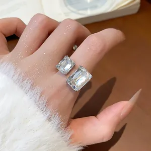 Gros plan d'une bague ouverte en argent avec deux cristaux rectangulaires étincelants