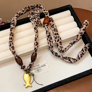 Collana in tessuto leopardato con perle di legno e ciondolo a forma di pesce dorato