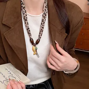 Collana in tessuto leopardato con perline di legno e un ciondolo a forma di pesce d'oro