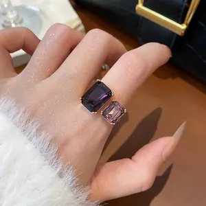 Gros plan d'une bague ouverte réglable avec deux pierres précieuses violettes carrées