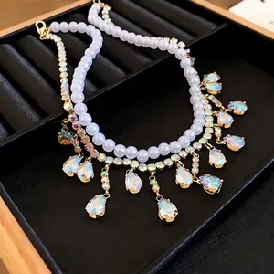 Elegant double-layered necklace featuring white pearls and rhinestone teardrop fringe