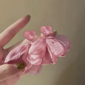 Vista dettagliata di orecchini a fiore in rete rosa con perni a forma di cuore marmoreo