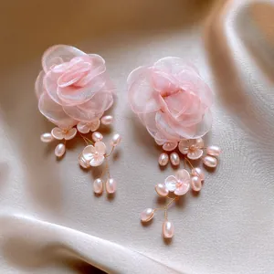 Elegantes pendientes de flores de tela rosa hechos a mano con perlas y oro.