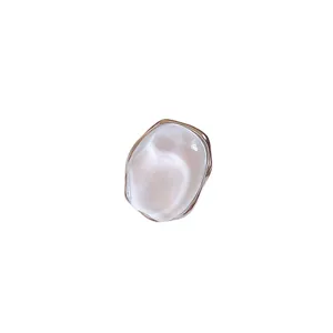 Minimalist pearlescent oval stud earrings with silver needle posts on white background.