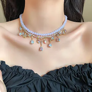 Detailed view of layered necklace with pearls and iridescent teardrop zircon fringe.