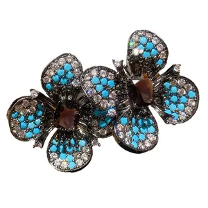 Orecchini a fiore vintage con turchese blu e strass brillanti in metallo scuro.