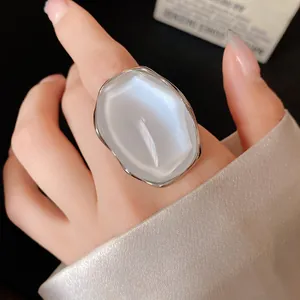 Close-up of a minimalist silver ring with a pearlescent oval stone