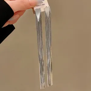 Detailed close-up view of elegant long silver tassel earrings with triangular studs for women