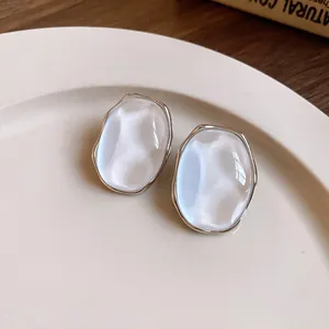 Macro view of elegant oval pearl luster stud earrings with silver-toned metallic edges