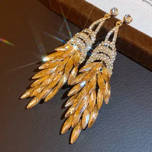 Primo piano di eleganti orecchini a pendente vintage dorati con brillanti cristalli ambrati