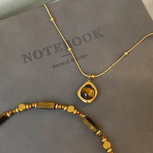 Detaillierte Nahaufnahme des Vintage-Tigerauge-Anhängers und der Goldkette