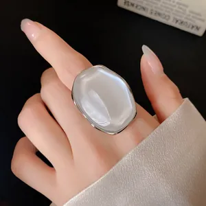 Macro detail of an elegant silver-plated ring with a large pearlescent oval stone.