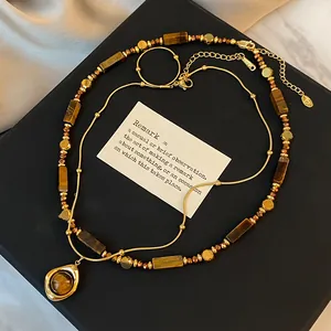 Detailansicht einer Vintage-Halskette mit Tigerauge-Steinen und vergoldeten Perlen für Damen.